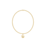 Gold bracelet with a single round charm on a white background. Available at Be Charmed