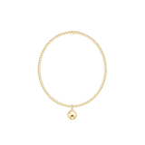 Gold bracelet with a single round charm on a white background. Available at Be Charmed