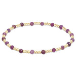 A bracelet with a series of gemstone beads in shades of purple and gold-filled beads, with a gold-filled clasp. Available at Be Charmed