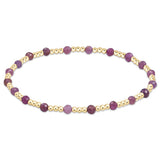 A bracelet with a series of gemstone beads in shades of purple and gold-filled beads, with a gold-filled clasp. Available at Be Charmed