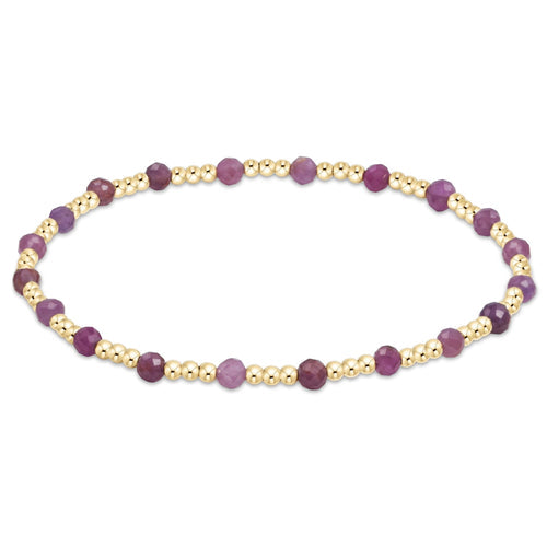 A bracelet with a series of gemstone beads in shades of purple and gold-filled beads, with a gold-filled clasp. Available at Be Charmed
