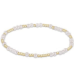 A bracelet with white pearls and gold-colored beads. Available at Be Charmed