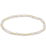 A bracelet with white pearls and gold-colored beads. Available at Be Charmed
