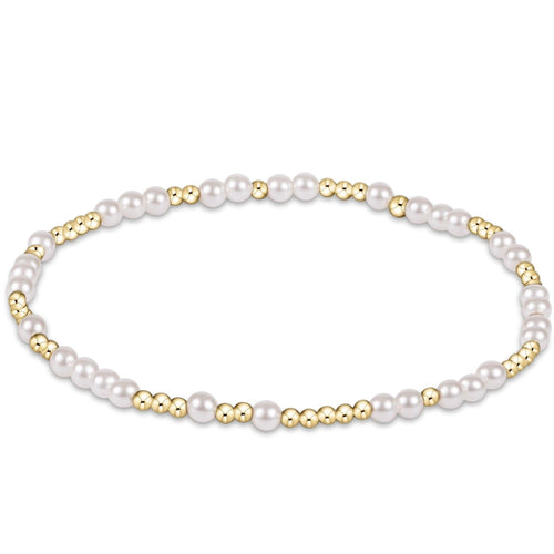 A bracelet with white pearls and gold-colored beads. Available at Be Charmed