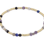 A bracelet with a mix of blue and purple gemstone beads and 14k gold-filled beads, featuring a gold-filled clasp. Available at Be Charmed