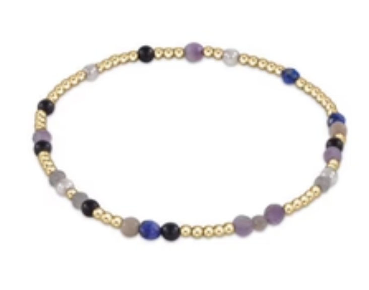 A bracelet with a mix of blue and purple gemstone beads and 14k gold-filled beads, featuring a gold-filled clasp. Available at Be Charmed