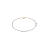 Thin white beaded bracelet with a gold clasp on a white background. Available at Be Charmed