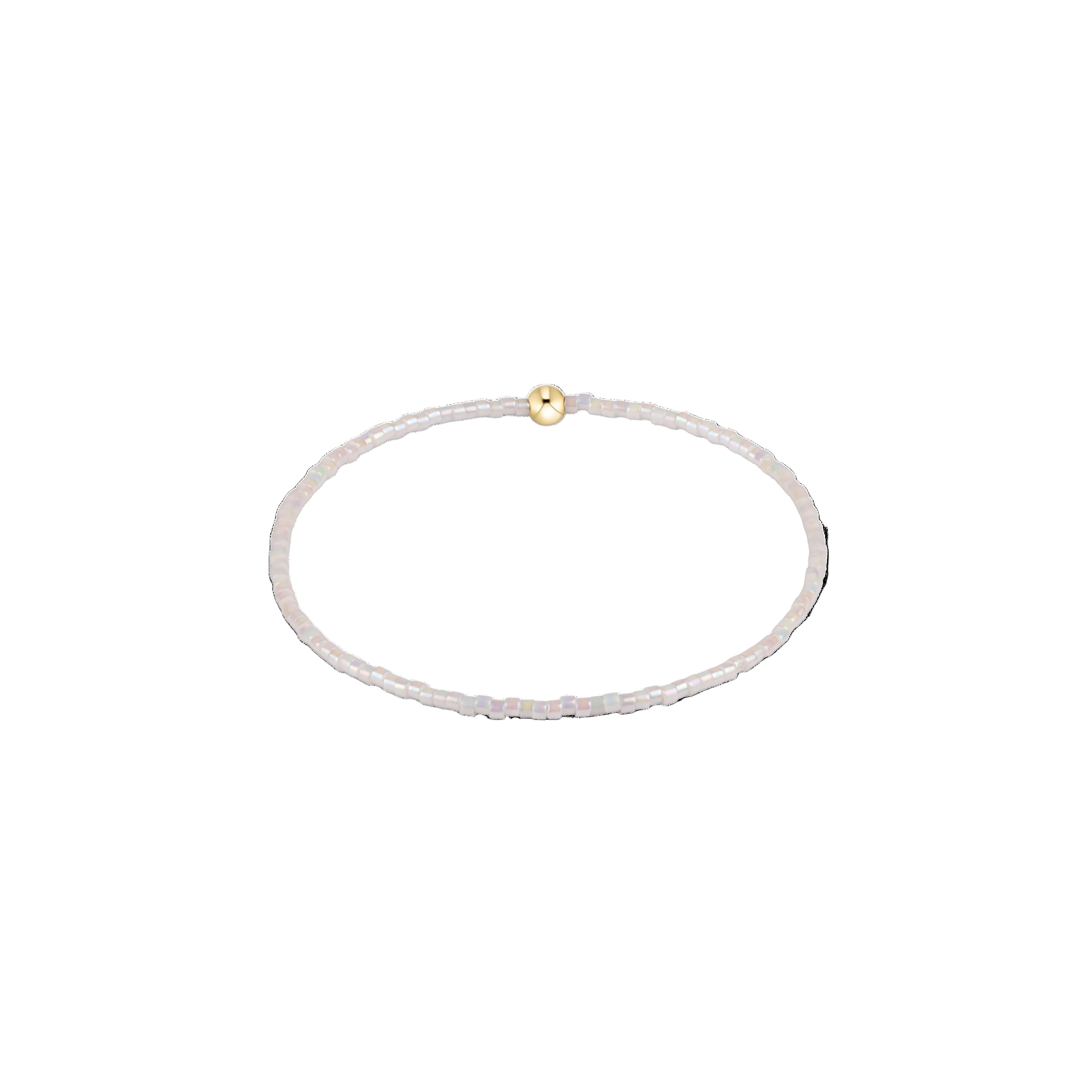 Thin white beaded bracelet with a gold clasp on a white background. Available at Be Charmed