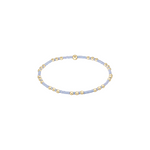 Delicate bracelet with gold and light blue beads on a white background. Available at Be Charmed