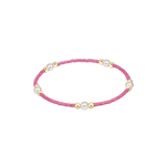 Bracelet with pink beads and gold accents on a white background. Available at Be Charmed