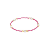 Bracelet with pink beads and gold accents on a white background. Available at Be Charmed