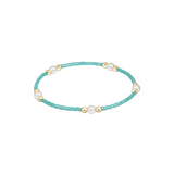 Turquoise beaded bracelet with pearls and gold accents on a white background. Available at Be Charmed