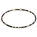 A bracelet with black onyx beads and gold-filled beads, featuring a mixed-color design. Available at Be Charmed