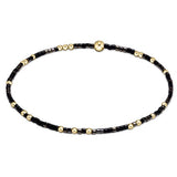 A bracelet with black onyx beads and gold-filled beads, featuring a mixed-color design. Available at Be Charmed