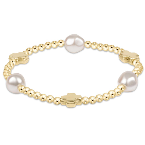 A gold-colored bracelet with a signature cross pattern and white pearls. Available at Be Charmed