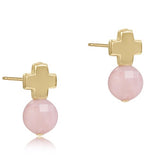 A pair of pink opal gemstone stud earrings with a gold-filled metal band and a signature cross design on the back. Available at Be Charmed