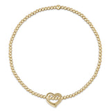 enewton A gold-filled bracelet with a chain of beads and a gold-filled heart-shaped charm. Available at Be Charmed