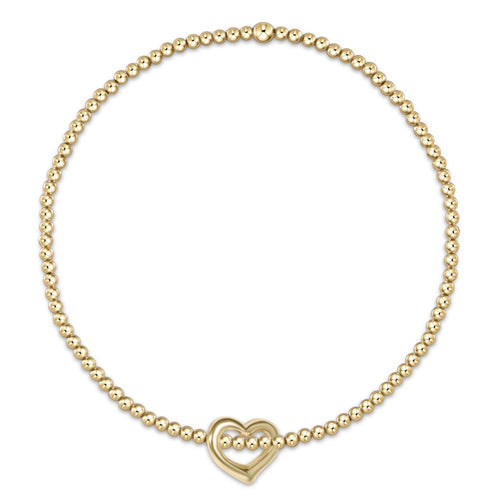 enewton A gold-filled bracelet with a chain of beads and a gold-filled heart-shaped charm. Available at Be Charmed