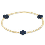 enewton Gold bracelet with navy blue cross charms on a white background. Available at Be Charmed