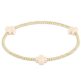enewton Gold bracelet with off white cross charms on a white background. Available at Be Charmed
