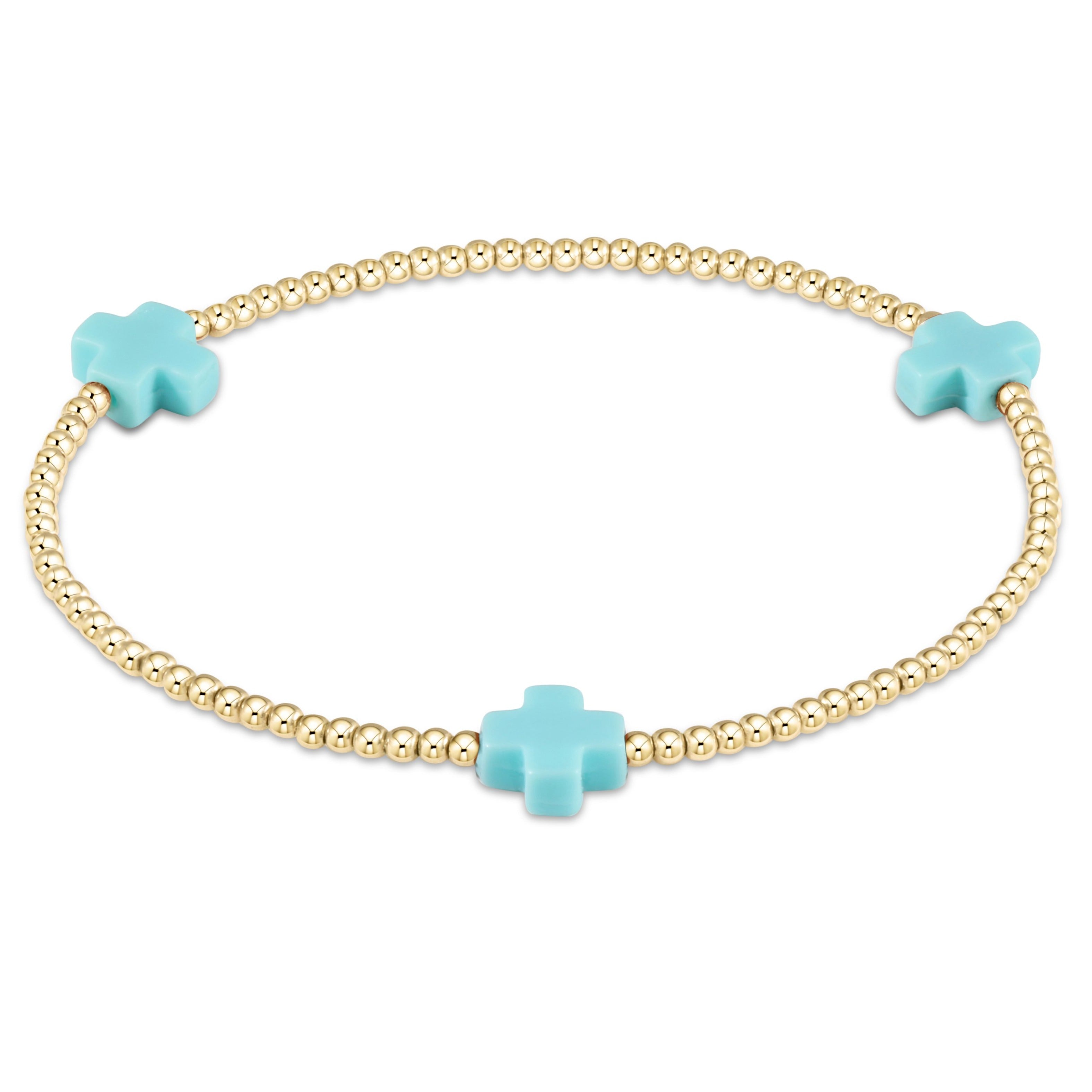 enewton Bracelet with gold beads and turquoise cross-shaped charms on a white background. Available at Be Charmed
