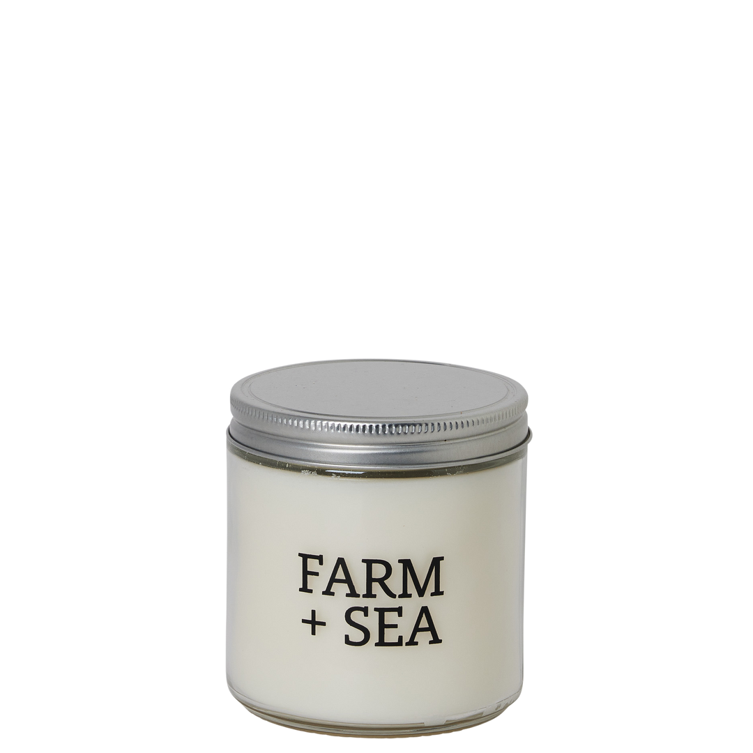 Candle jar with 'Farm + Sea' branding on a white background. Available at Be Charmed