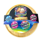 Mystery Dumpling packaging with colorful text and a gold lid on a white background. Available at Be Charmed