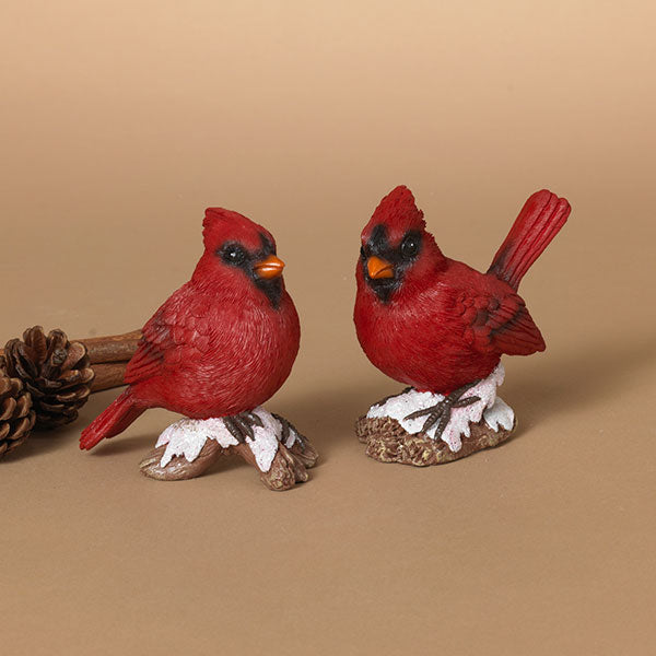 Two red cardinal bird figurines on a beige background. Available at Be Charmed