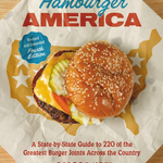 Book cover of 'Hamburger America' with a burger illustration on a wooden surface. Available at Be Charmed