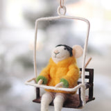 Decorative mouse ornament in a yellow sweater sitting on a swing against a blurred natural background. Available at Be Charmed
