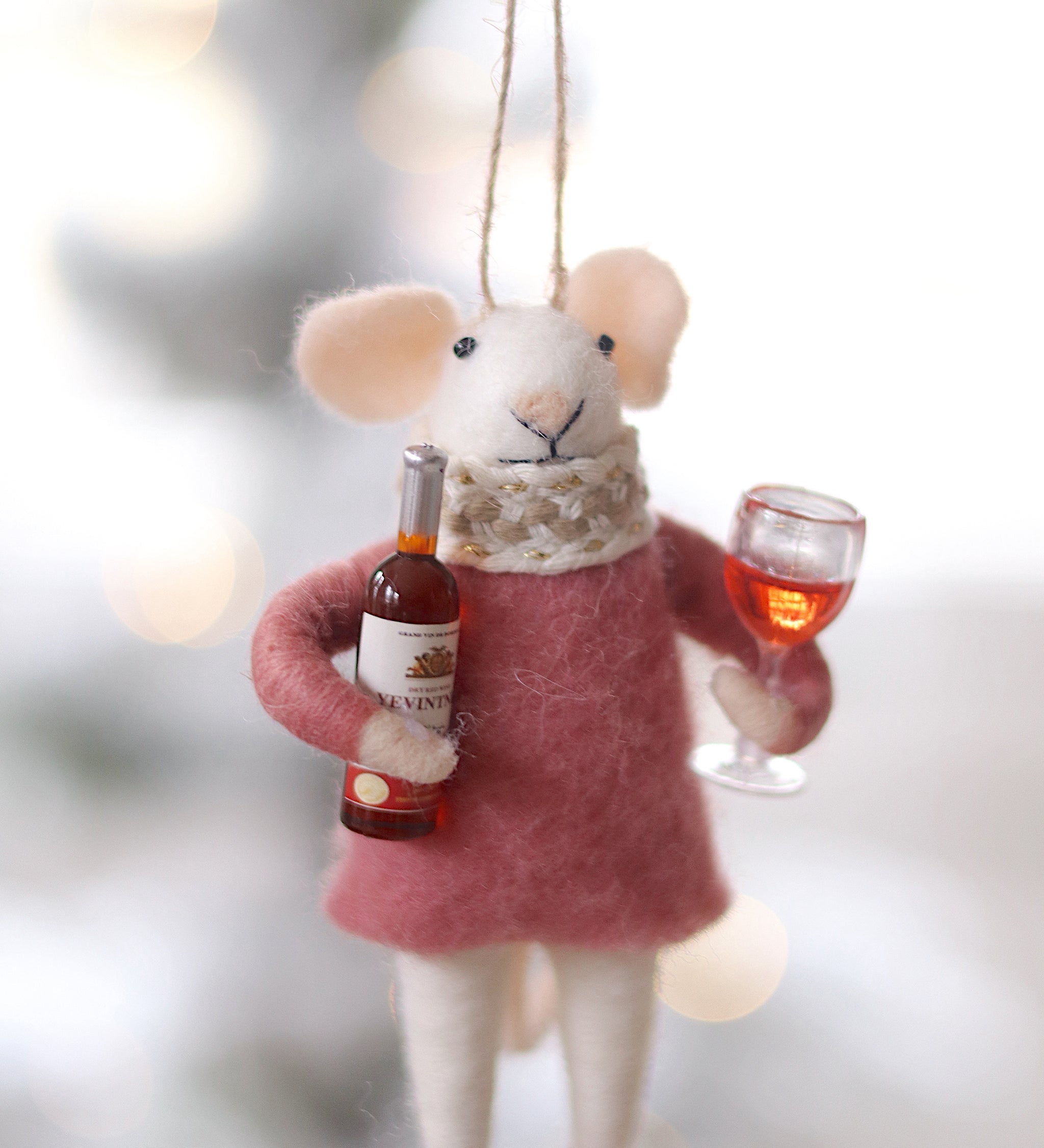 Decorative mouse ornament holding a bottle and glass against a blurred background. Available at Be Charmed