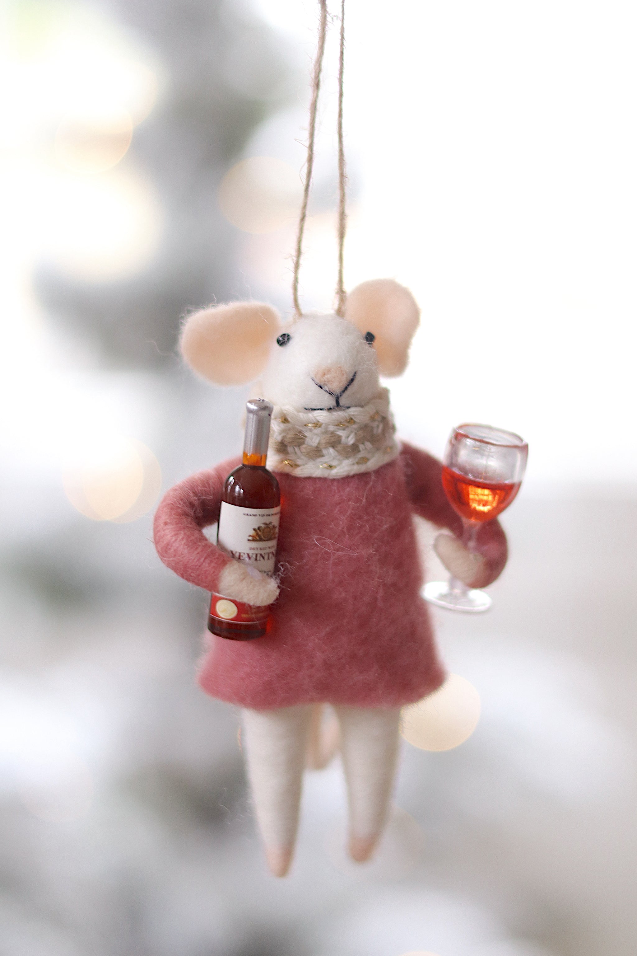 Decorative mouse ornament holding a bottle and glass against a blurred background. Available at Be Charmed