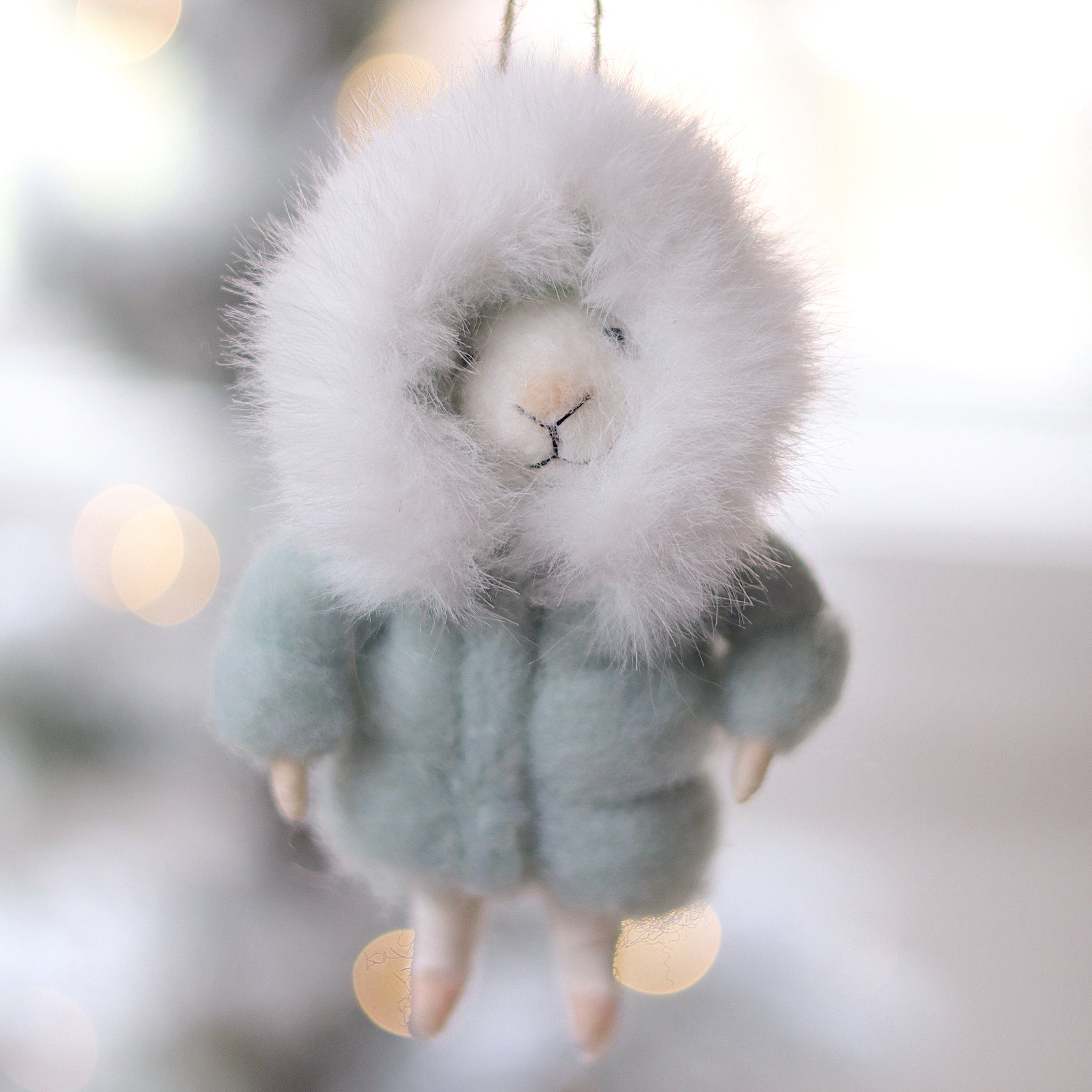 Felted mouse ornament hanging against a blurred snowy background.  Available at Be Charmed