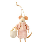 Mouse ornament in a pink coat holding a white bag on a beige background