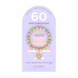 Jilzarah 60th birthday bracelet on a purple card with text. Available at Be Charmed.