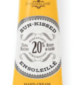 Hand cream tube labeled 'Sun-Kissed' by L'Chanteclaire on a white background. Available at Be Charmed