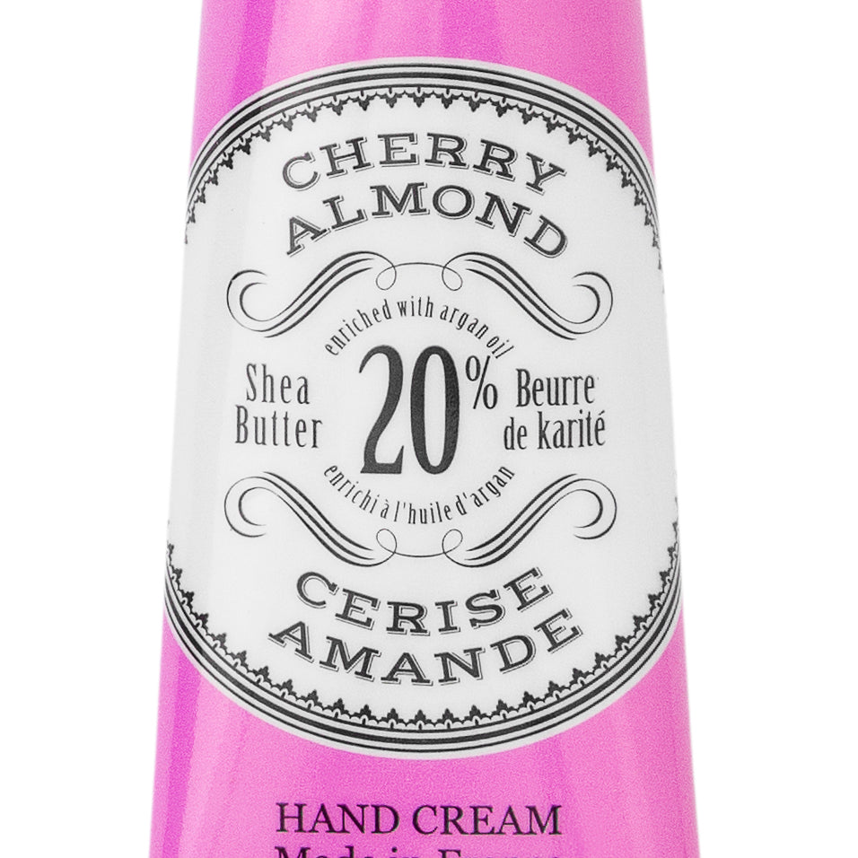 Purple hand cream tube labeled 'Cherry Almond' with branding on a white background. Available at Be Charmed