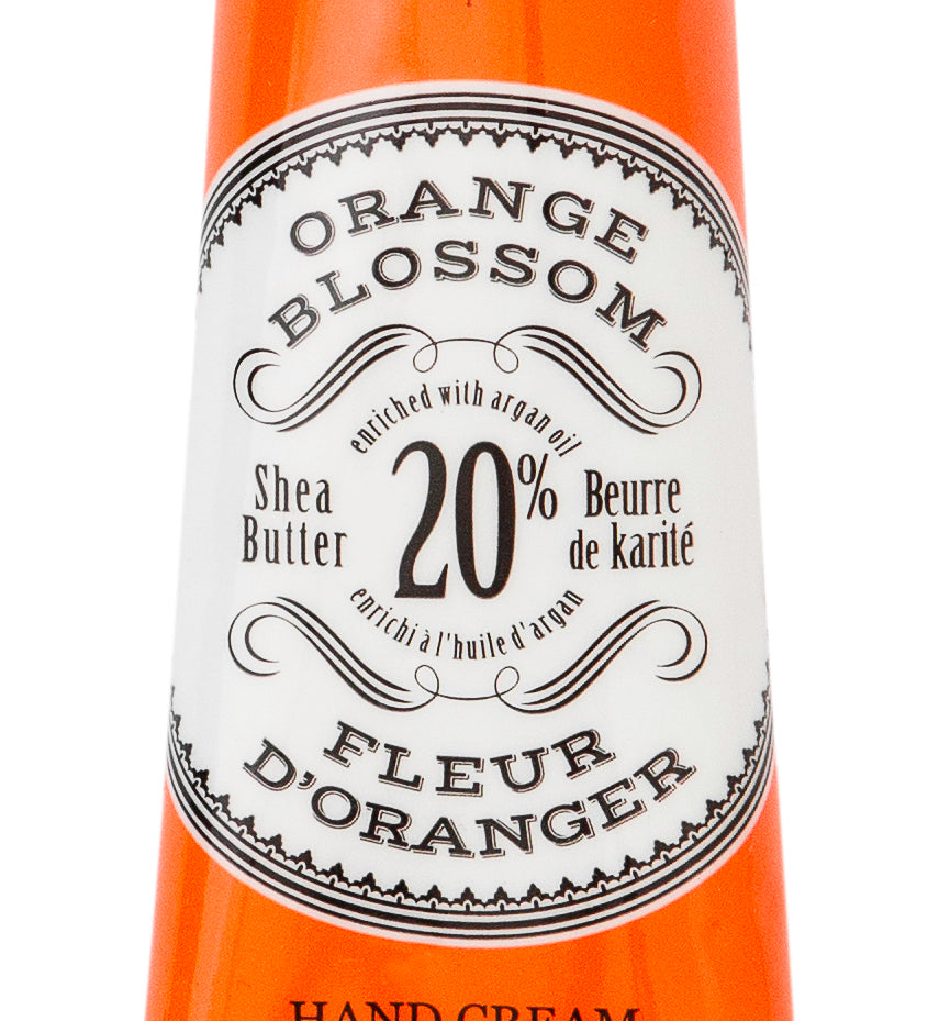 Hand cream tube labeled 'Orange Blossom' by L'Chanteclaire on a white background. Available at Be Charmed