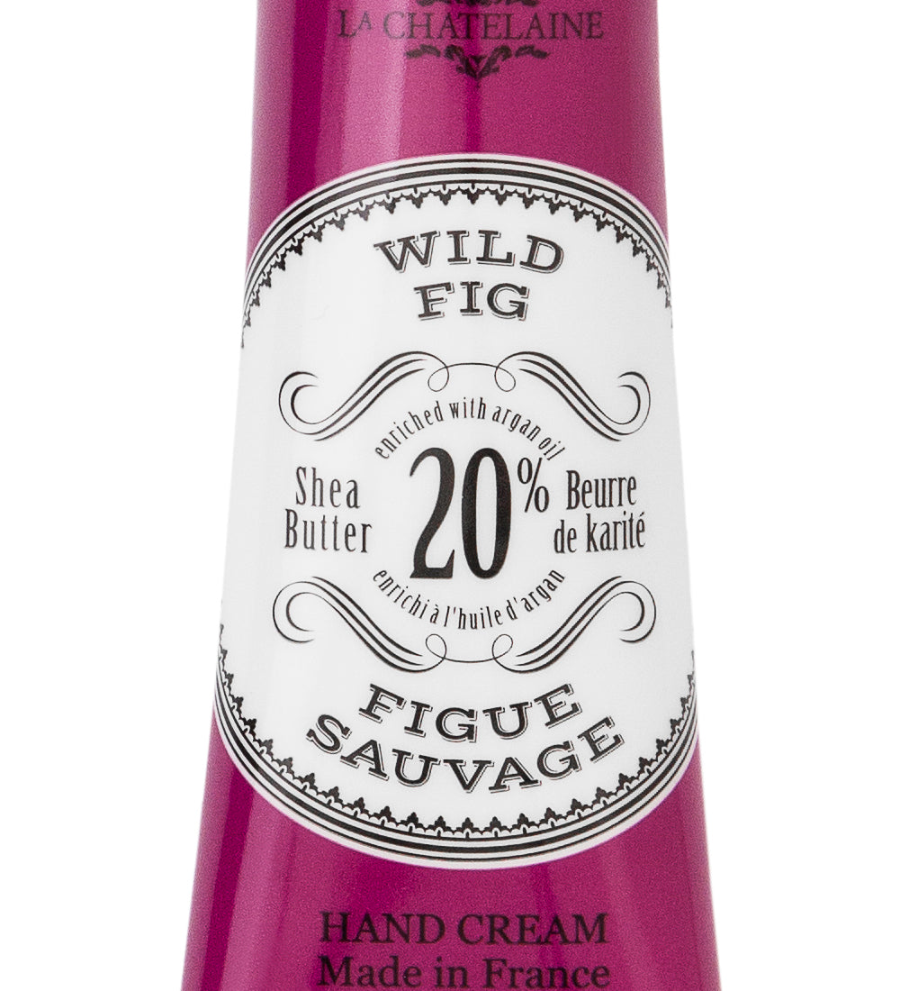 Hand cream tube labeled 'Wild Fig' with branding on a white background. Available at Be Charmed