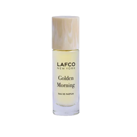 A small cylindrical glass bottle of LAFCO New York Golden Morning Eau de Parfum with a marbled beige cap, set against a plain white background. Available at Be Charmed