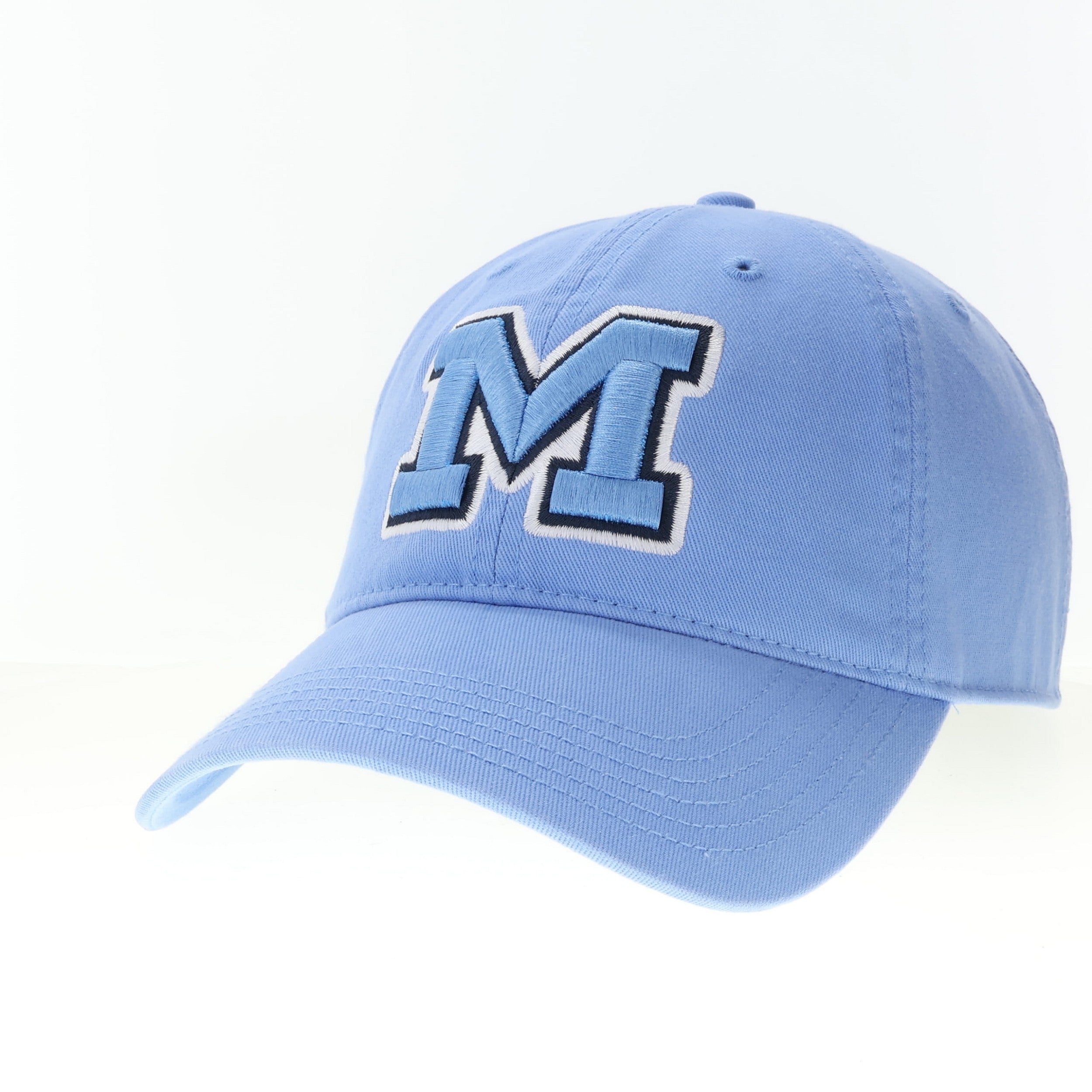 Light blue cap with a large 'M' logo on a white background. Available at Be Charmed