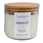 Candle jar with wooden lid and 'Lola & Bean Co.' label on a white background. Available at Be Charmed