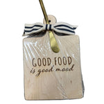 Wooden board with 'Good food is good mood' text, wrapped in cellophane with a ribbon and gold bow. Available at Be Charmed