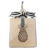 Square wooden cutting board with pineapple design and ribbon on a white background. Available at Be Charmed