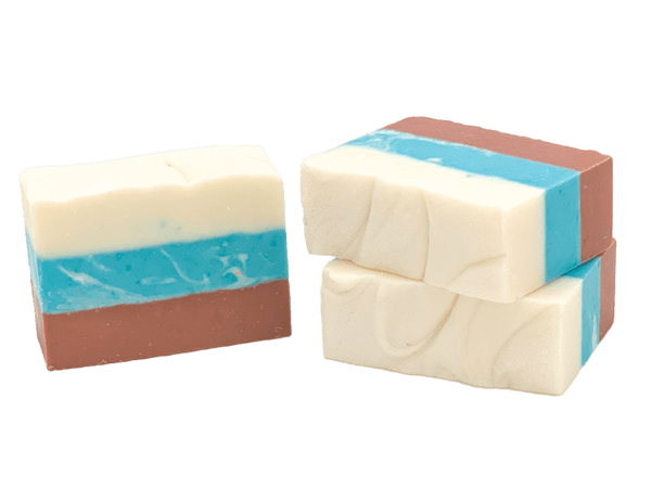 Three bars of soap with layered colors on a white background. Available at Be Charmed
