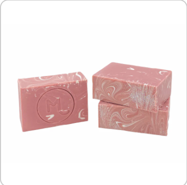 Pink soap bar with decorative design on a white background. Available at Be Charmed