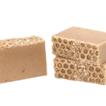 Two beige soap bars with honeycomb texture on a white background. Available at Be Charmed