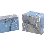 Three bars of marbled soap in blue and gray on a white background. Available at Be Charmed