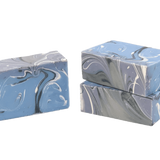 Three bars of marbled soap in blue and gray on a white background. Available at Be Charmed
