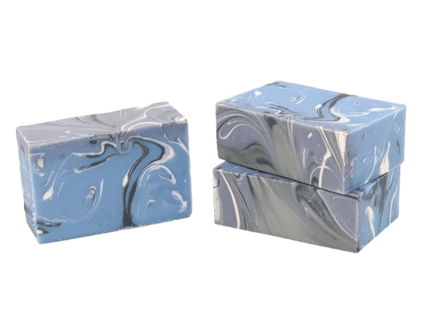 Three bars of marbled soap in blue and gray on a white background. Available at Be Charmed